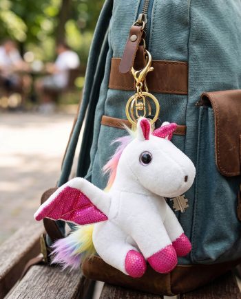 Teal backpack with brown leather straps and a white plush unicorn keychain hanging from the zipper pull.