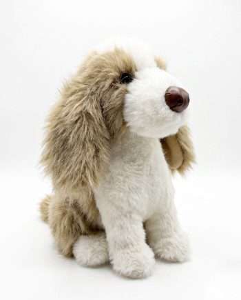 Soft beige and white plush dog toy sitting on a white background
