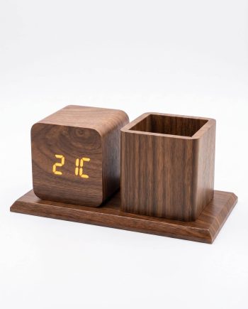Wooden desk clock with an orange digital display reading 21°C, paired with a matching open-square pen cup on a wood base.