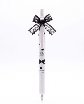 White polka-dotted pen decorated with black lace bows at the top and lower section, used for writing.