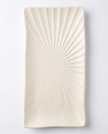 Rectangular white ceramic plate with a sunburst pattern of radiating ridges starting from the bottom left corner and speckled glaze.